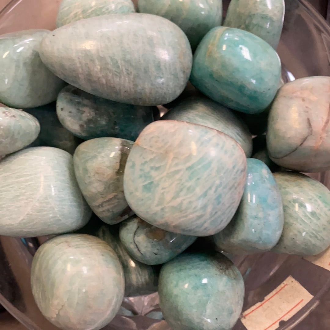Amazonite tumbles in a jar.